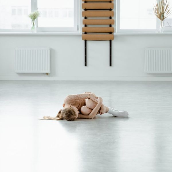 Minimalist yoga studio with dark walls and wooden floor